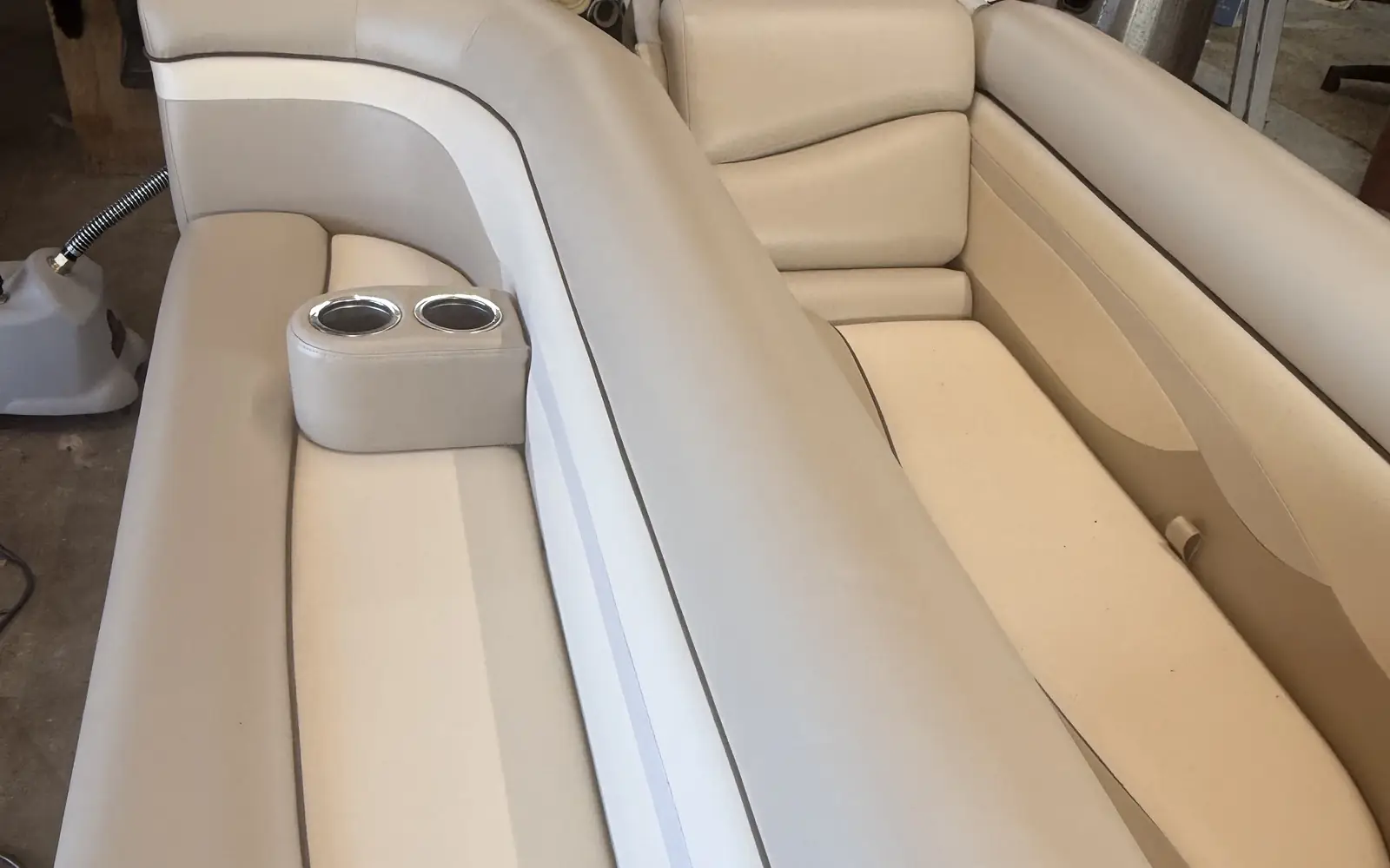 Re-covered pontoon bench seats in cream and taupe vinyl with cup holders